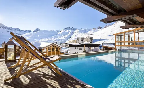 View of the outdoor pool and surrounding mountains from Hôtel Les Campanules in Tignes